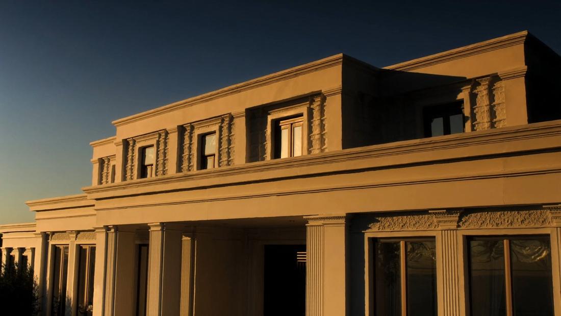 A CLADECO® facade — coated-EPS cornices, columns and cladding on a villa exterior at golden hour